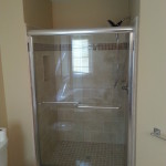 Completed tile shower with the clear glass shower door installed